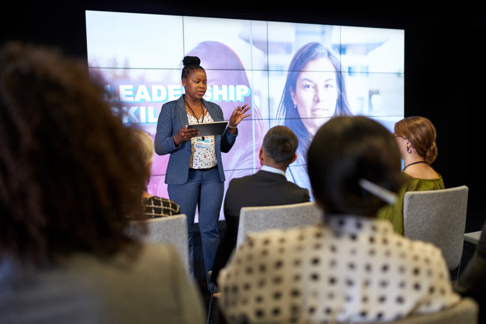 Woman delivering a speech on a stage during an event